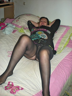 Chubby housewife in black pantyhose on the bed